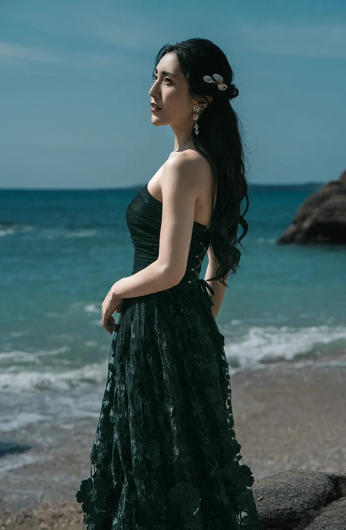 海辺の岩場に佇む、Jediaのブラックドレスを纏った新婦の横顔