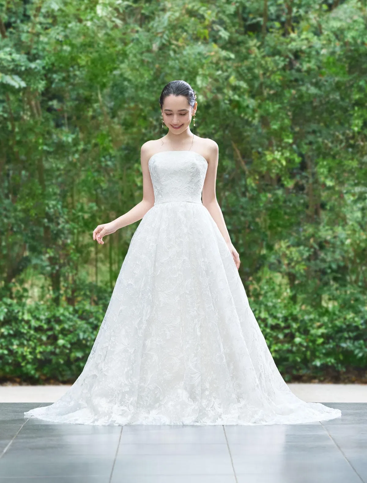 緑とのコントラストが美しいレースやバックデザインのドレス