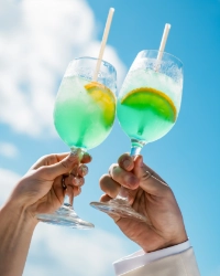 海を背景にカクテルで乾杯する様子