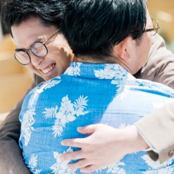 家族と抱き合う新郎